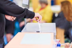 Voter putting envelope in ballot box