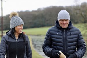 Two midlife adults walk in British countryside