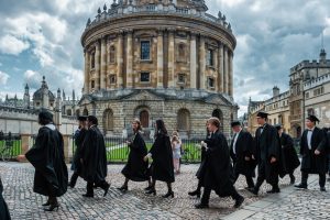 A group of university graduates walking together outside a university building.